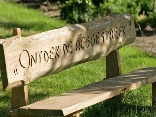 a wooden bench with writing on the back of it at Stylish Farmhouse Escape in Wierden