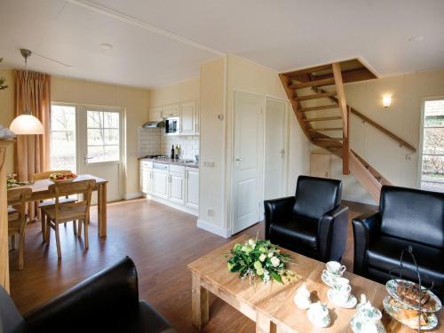 a living room with a table and chairs and a kitchen at Stylish Farmhouse Escape in Wierden
