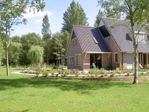 a house with a solar roof on a yard at Rural holiday home with terrace in Zuidwolde