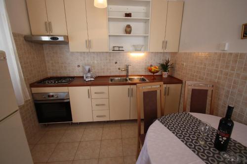 a small kitchen with white cabinets and a sink at BRNIC 2 in Jadranovo