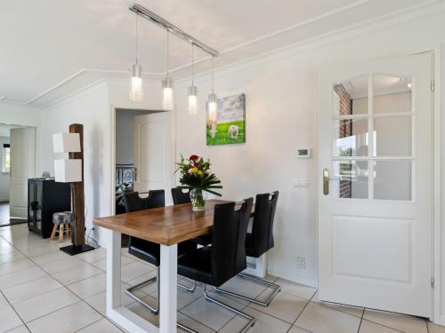 a dining room with a wooden table and black chairs at Quaint Holiday Home in Putten with Garden in Putten
