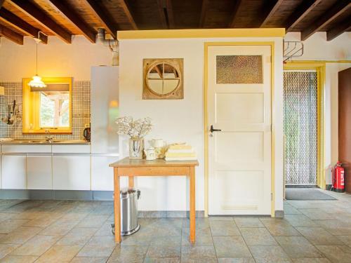 eine Küche mit einem Tisch und einer weißen Tür in der Unterkunft Holiday cottage in Schijf with a fenced garden in Schijf