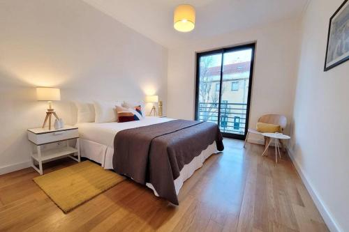 a bedroom with a large bed and a large window at Marble Home - São Sebastião in Lisbon