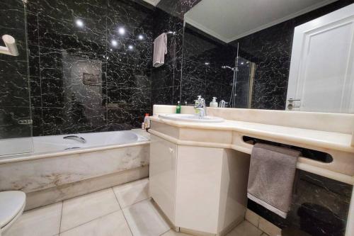 a bathroom with a sink and a tub and a toilet at Marble Home - São Sebastião in Lisbon