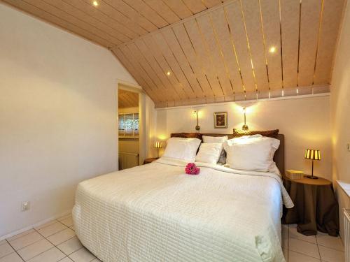 オーストカペッレにあるComfortable apartment in a quiet area nearby woods and beachのベッドルーム1室(ピンクの花が咲く白いベッド1台付)
