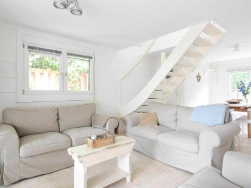 - un salon avec un canapé et un escalier dans l'établissement Cozy house with sauna in Oostkapelle with forest, à Oostkapelle