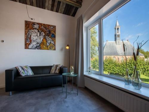 a living room with a couch and a large window at Modern Apartment in Koudekerke near Seabeach in Koudekerke