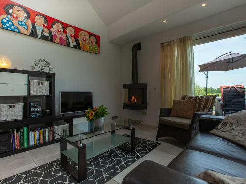 sala de estar con sofá y chimenea en Luxury holiday home with private terrace, en Langweer