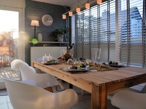 a dining room with a wooden table and white chairs at Cosy Holiday Home in Noordwijkerhout near Lake in Noordwijkerhout