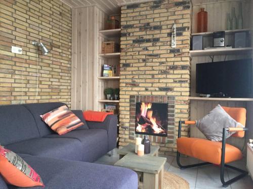 a living room with a couch and a fireplace at Secluded Holiday Home in Ballum Frisian Islands in Ballum