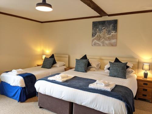 two beds in a bedroom with two lamps at Sparkford Inn in Sparkford