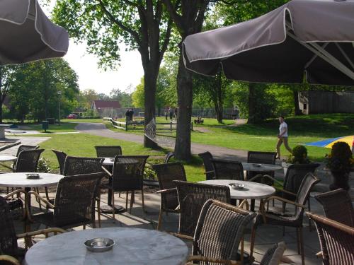 een groep tafels en stoelen in een park bij Cozy apartment in a farmhouse in Camino-Ombra in Westerbork