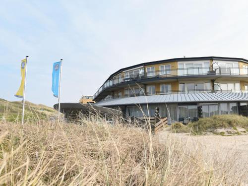 um edifício situado no topo de uma praia arenosa em Modern suites near beach em Callantsoog