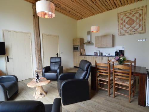a living room with chairs and a table and a kitchen at Farmhouse in Geesteren near Forests in Geesteren