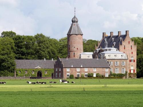 a large building with a herd of cows in a field at Tranquil Forest Retreat in Dalfsen