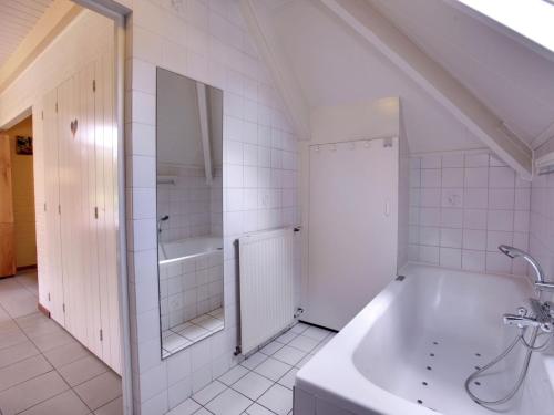 a bathroom with a tub and a shower and a sink at Tranquil Forest Retreat in Dalfsen