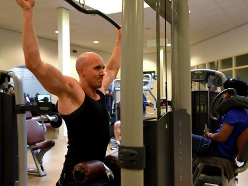 a man in a gym performing a pull up exercise at Tranquil Forest Retreat in Dalfsen