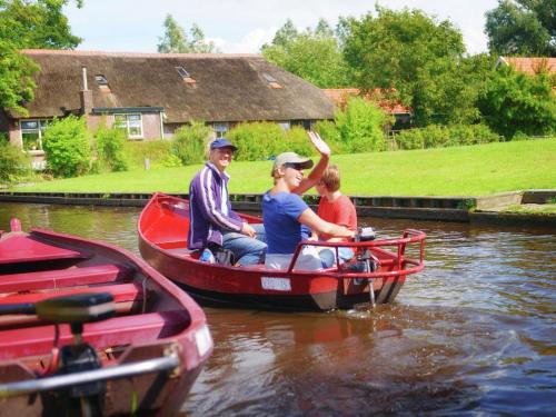 a group of people in a boat on the water at Holiday home in De Bult near Giethoorn Waters in De Bult