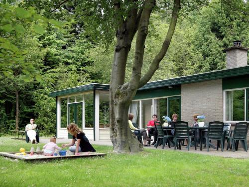 a group of people sitting in the grass at Holiday home in De Bult near Giethoorn Waters in De Bult