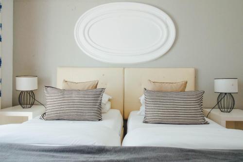 two white beds with white pillows and pillows at Baluarte da Vila Apartments in Lagos