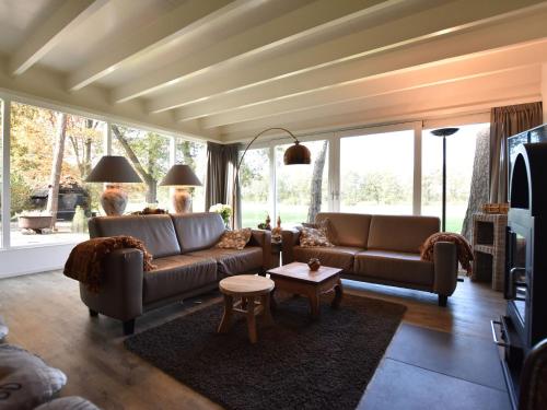 Sala de estar con 2 sofás y mesa en Holiday Home in Reutum Weerselo with Jacuzzi, en Beekdorp