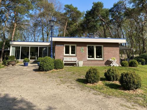 a small red brick house with a porch at Holiday Home in Reutum Weerselo with Jacuzzi in Beekdorp