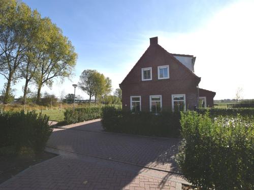 a red house on a street with a driveway at house in a quiet park with sauna in Breskens