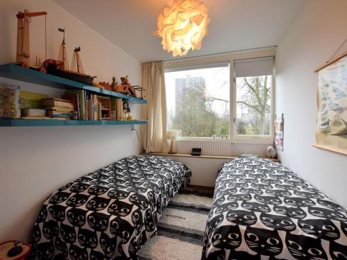 a bedroom with two beds and a window at Terrace Apartment with Lush Garden in Voorburg
