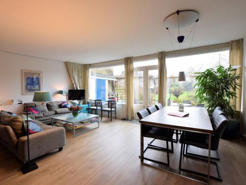 a living room with a couch and a table at Terrace Apartment with Lush Garden in Voorburg