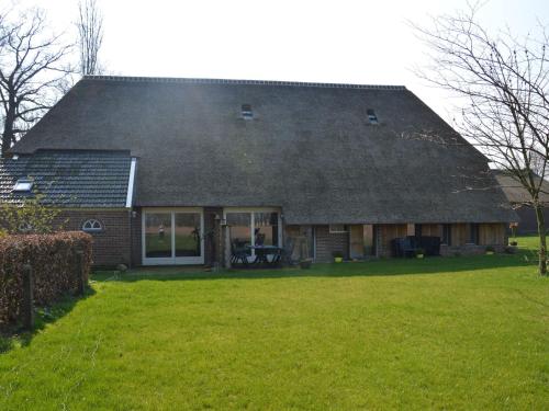 een huis met een grote tuin ervoor bij Staying in a thatched barn with bedroom and box bed beautiful view Achterhoek in Geesteren