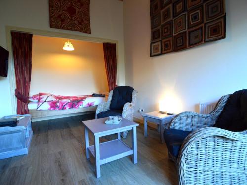 a room with a bed and two chairs and a table at Romantic Farmhouse Escape in Geesteren