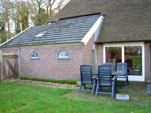 a group of chairs sitting around a table in a backyard at Romantic Farmhouse Escape in Geesteren