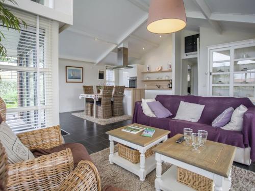 KattendijkeにあるAttractive holiday home with large terraceの紫色のソファとテーブル付きのリビングルーム