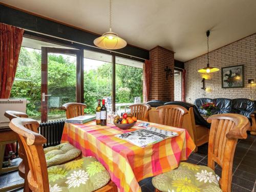 un comedor con una mesa con un bol de fruta. en Comfortable detached bungalow 65 m2, en Kamperland
