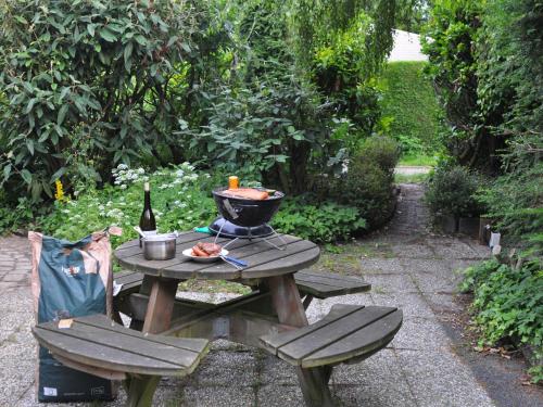 una mesa de picnic con un plato de comida y una botella de vino en Comfortable detached bungalow 65 m2, en Kamperland