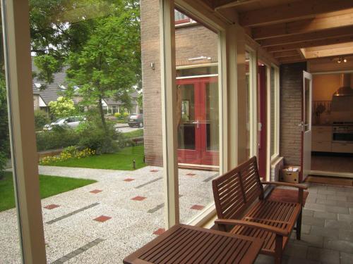 una veranda riparata con panchina su una casa di Tranquil holiday home in West Gradijk a West-Graftdijk
