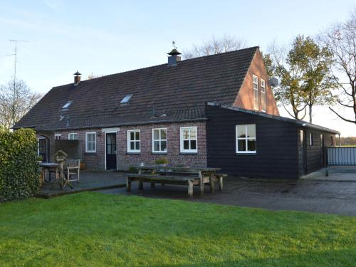 una casa con una mesa de picnic delante de ella en Linked farm in Elsendorp with a recreation barn, en Elsendorp