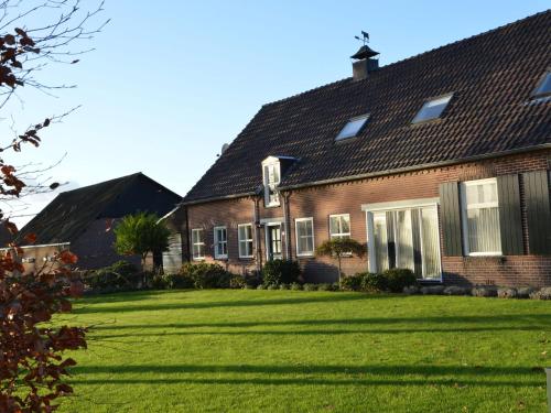 a house with a large lawn in front of it at Linked farm in Elsendorp with a recreation barn in Elsendorp