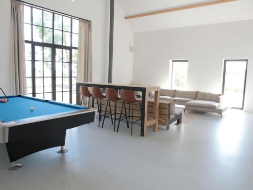 a living room with a pool table and chairs at Elegant Farmhouse in Zuidzande with Private Garden in Zuidzande