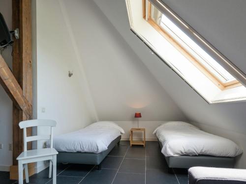 two beds in a attic room with a window at Spacious farmhouse in wooded area in Zuidoostbeemster