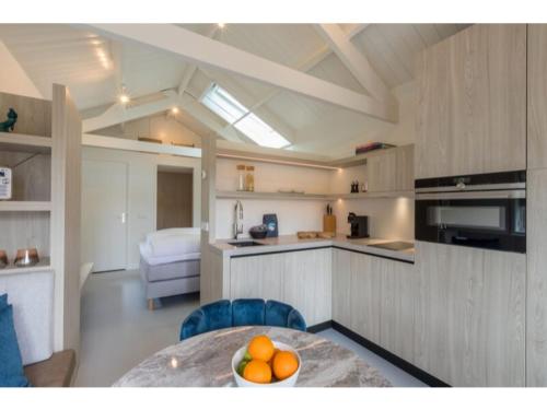 a kitchen with a table and a bowl of oranges at Luxury holiday home 250 meters from the beach in Domburg
