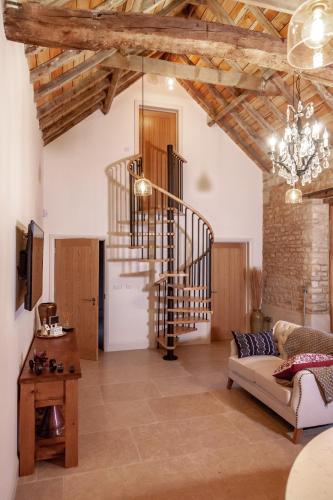 a living room with a staircase and a couch at The Studio in Castle Bytham