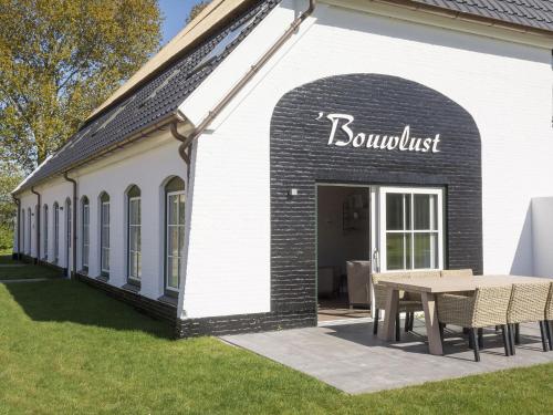 a building with a table outside of it at Apartment in cozy farmhouse in De Cocksdorp