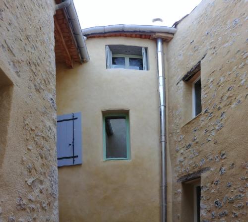 una vista exterior de un edificio con dos ventanas en Gîte Pilpoil, en Sault-de-Vaucluse