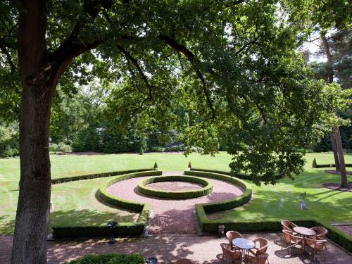 un jardín con sillas y un reloj en el medio en Country house in nature en Oldenzaal