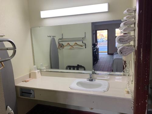baño con lavabo y espejo grande en Budget Inn, en Saint George