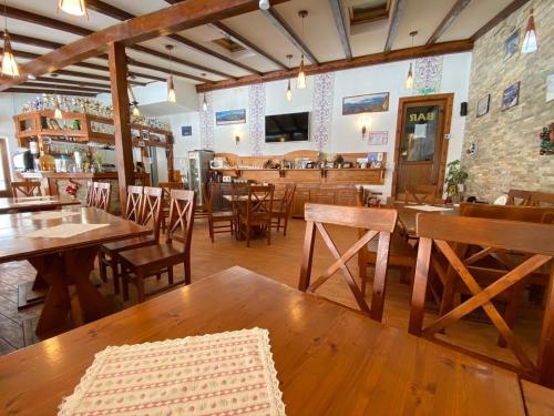 un restaurante con mesas de madera y sillas en una habitación en Pensiunea Pasul Clabucetului, en Predeal