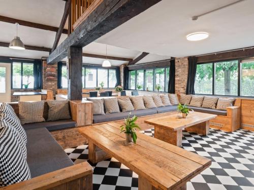een restaurant met banken en tafels in een kamer bij Spacious farmhouse in Limburg near forest in Sint Antoniusbank