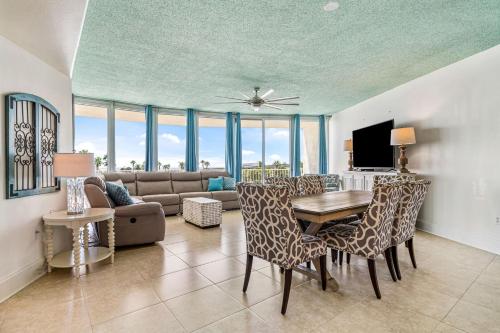 uma sala de estar com uma mesa e cadeiras e um sofá em Newly Updated Caribe 213B em Orange Beach