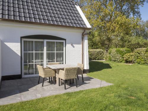 a patio with a table and chairs in a yard at Apartment in tasteful farmhouse in De Cocksdorp on the Wadden island of Texel in De Cocksdorp